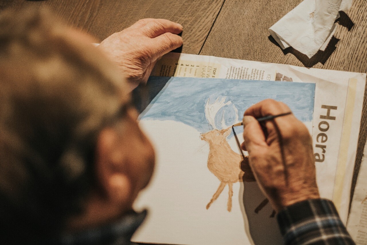 Een deelnemer van de Zorghoeve is aan het schilderen