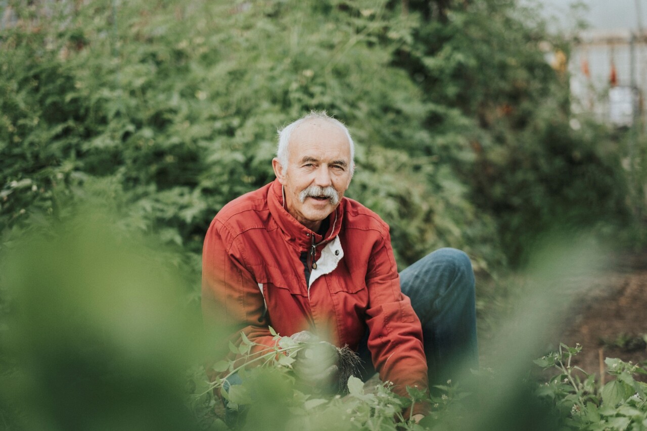 Een deelnemer van de dagbesteding is aan het werk in de moestuin.